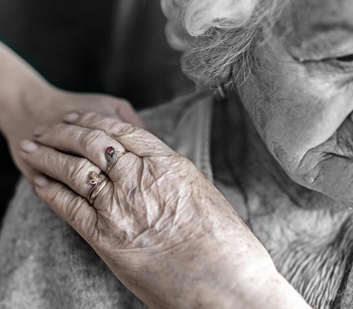 A kind hand being held by an elderly woman's hand.